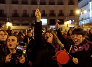 Women bang pots and pans during a protest