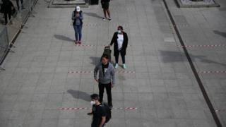 People are seen following social distancing rules as they queue outside a Tesco supermarket in Kensington, as the spread of the coronavirus disease (COVID-19) continues,