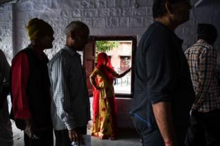 Индийцы, в том числе женщина, у кабины для голосования