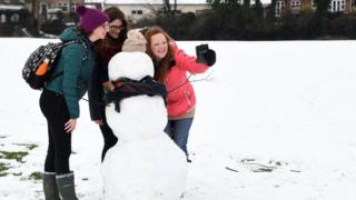 Woman take a selfie with a snowman in High Wycombe, Buckinghamshire.