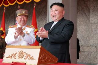 На этой фотографии от 15 апреля 2017 года, опубликованной официальным корейским Центральным агентством новостей (KCNA) Северной Кореи 16 апреля 2017 года, изображен северокорейский лидер Ким Чен Ун (справа) на военном параде в Пхеньяне, посвященном 105-й годовщине со дня рождения покойного северокорейского лидера. Ким Ир Сен.