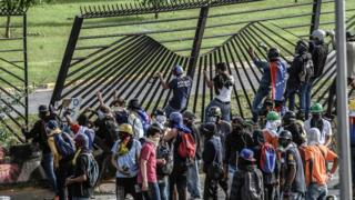 Manifestantes tratan de entrar a la base aérea de La Carlota