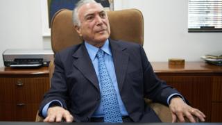 Bolsonaro olha para cima sentado na poltrona de seu escritório