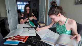 Two teenage girls do homework, April 2020