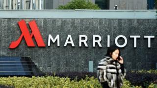 a woman walking past Marriott signage in Hangzhou in China's Zhejiang province.