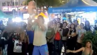 Man swinging baby by the legs