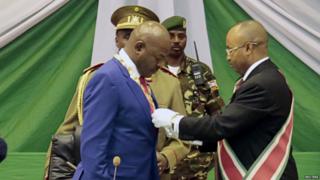 Pierre Nkurunziza (L) receives a symbolic chain at the Congress Palace in Kigobe district, Bujumbura, August 20, 2015.