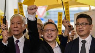 Baptist minister Chu Yiu-ming, 74, law professor Benny Tai, 54, and sociology professor Chan Kin-man, 59, shout slogans with supporters before entering the West Kowloon Magistrates Court in Hong Kong on November 19, 2018.