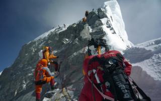 Неизвестные альпинисты проходят мимо Хиллари Стэп, выступая на вершину Эвереста 19 мая 2009 г.