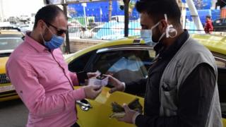 Un homme paie de l'essence dans une station-service à Damas, en Syrie (28 mars 2020)