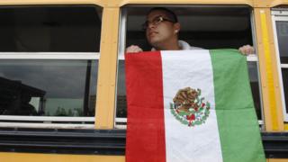 Un alumno despliega una bandera de México en un autobús escolar en Texas, EE.UU.