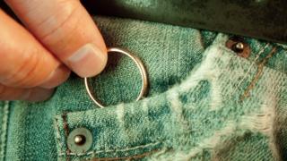 Detalle de jean de hombre con su mano metiendo un anillo al bolsillo