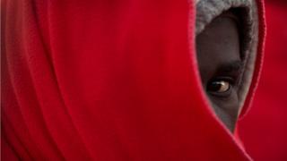 A migrant awaits disembarking upon their arrival at the harbour of Malaga, Spain - Sunday 6 January 2019