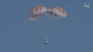 The SpaceX Dragon capsule deployed parachutes as it approached the surface of the Atlantic Ocean