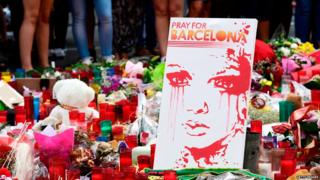 Velas y una pintura de una joven llorando tras el atentado del