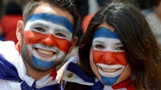 Dos costarricenses con los rostros pintados