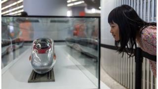 A girl looks at a model of the 'Vibrant Express' train on display at the West Kowloon terminus during an open day to the public in Hong Kong on September 1, 2018.