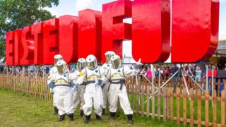 Знак Eisteddfod с людьми, одетыми как космонавты, перед знаком