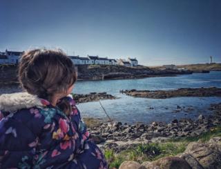 girl looking towards Portnahaven, Islay