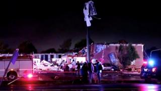 Emergency vehicles are seen near a partially collapsed building after a tornado touched down in El Reno, Oklahoma