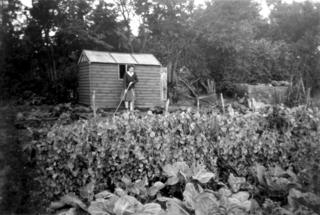Eileen Newell in front of a garden shed