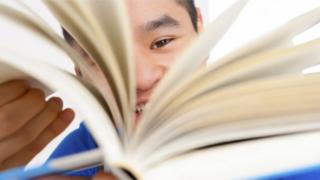 estudiante chino hojeando libro
