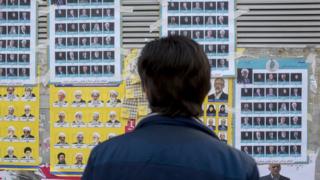 An Iranian man looks at election posters