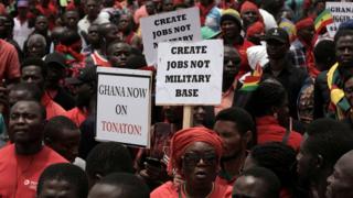 Demonstrators carry banners as they march during a protest in Ghana"s capital Accra against the expansion of its defence cooperation with the United States