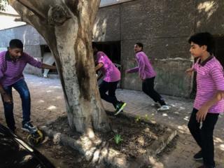 Students play football in street at the end of the study day on September 24, 2018 in Cairo, Egypt.