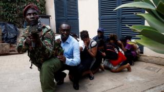 Люди были эвакуированы сотрудником сил безопасности на месте, где были слышны взрывы и выстрелы в гостиничном комплексе Dusit, в Найроби, Кения, 15 января 2019 года.