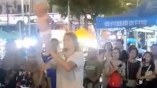 Man swinging baby by the legs