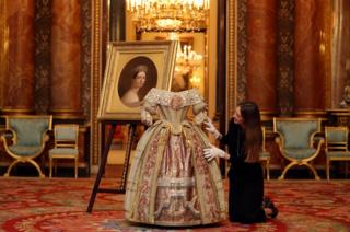 A Buckingham Palace staff member poses with Queen Victoria's Stuart Ball costume at the press preview of Queen Victoria's Palace which goes on public display from July 20 at the Summer Opening of the State Rooms at Buckingham Palace in London, Britain, 2 April 2019.