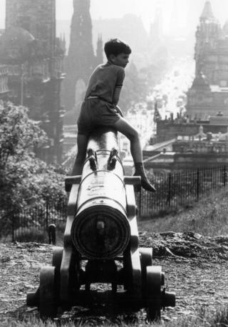 Boy sat on top of a cannon on Calton Hill, 1966.