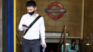 A man wearing a face mask leaves Leicester Square Underground Station in central London - 28 August 2020