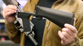 Un hombre sostiene un bump stock