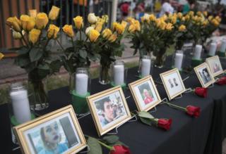 Фотографии жертв школьной стрельбы в Санта-Фе рядом с белыми свечами и желтыми розами