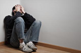 Sad man with depression sitting on the floor.