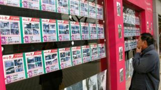 A man looks at property listings in Beijing