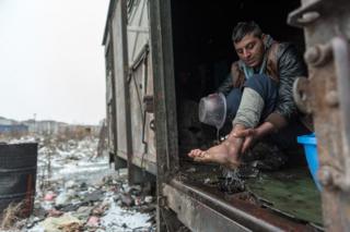 A man washes his foot in a shelter