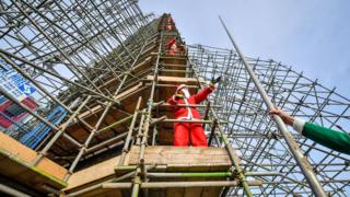 Santas erecting scaffolding around the Wellington Monument