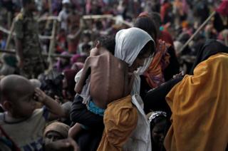 Una mujer carga a su hijo enfermo en un campo de refugiados en Bangladesh.