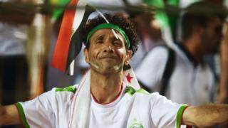 مشجع جزائري يرفع العلم المصري على رأسه خلال مباراة نصف النهائي أمام نيجيريا