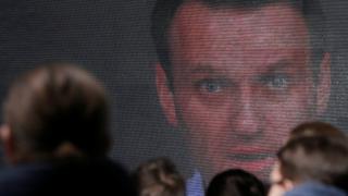 Alexei Navalny appears on a screen at his Moscow nomination meeting