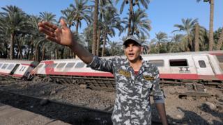 A police officer in front of a passenger train which derailed in al-Badrasheen, Egypt - Friday 13 July 2018