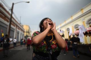 A woman yells slogans during a protest march in Guatemala City