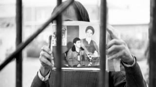 Eyleme katılan öğrencilerden biri, rehin tuttuğu kişinin fotoğrafını gösteriyor