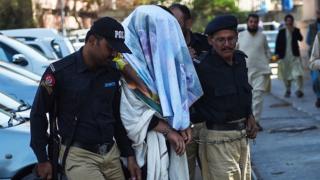 پاکستاني پولیسو د پښتون ژغورنې غورځنګ نیول شوی غړی عالمزیب محسود محکمې ته بیايي، چې مخ یې پټ کړی دی.