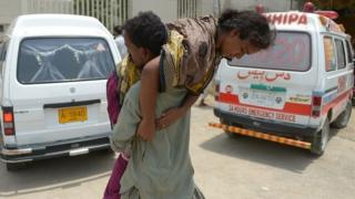 A Pakistani man carries a heatstroke victim into a hospital in Karachi on June 23, 2015