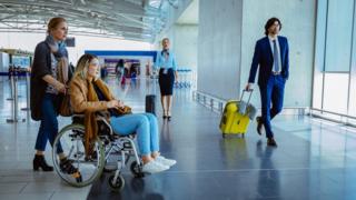 Crowd of people with luggage at international airport - stock photo