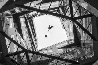 A black and white image of glass and walls in a building